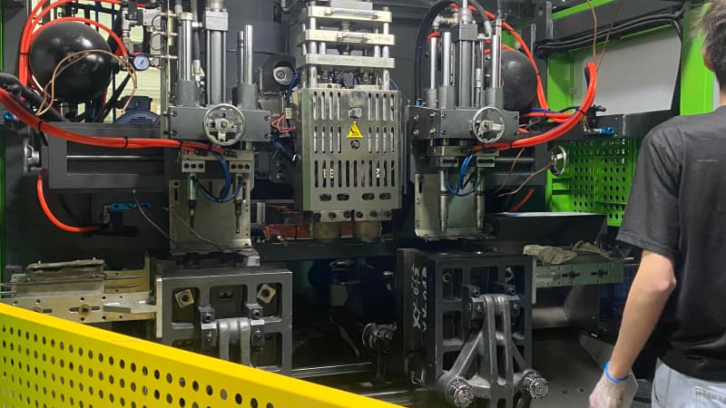 Internal mold and pneumatic structure of the blow molding machine with adjusting handwheels, operator working beside it