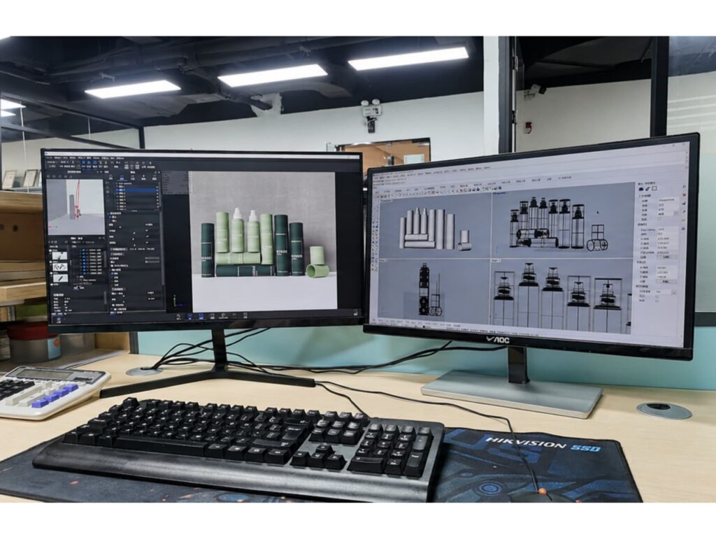 Two dual monitors show cosmetic packaging 3D renderings and product mold drawings, displaying our custom design capacity