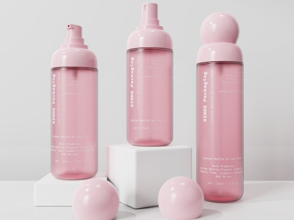 Three pink spherical-cap PET cosmetic spray bottles with different pump designs, displayed on white geometric display blocks