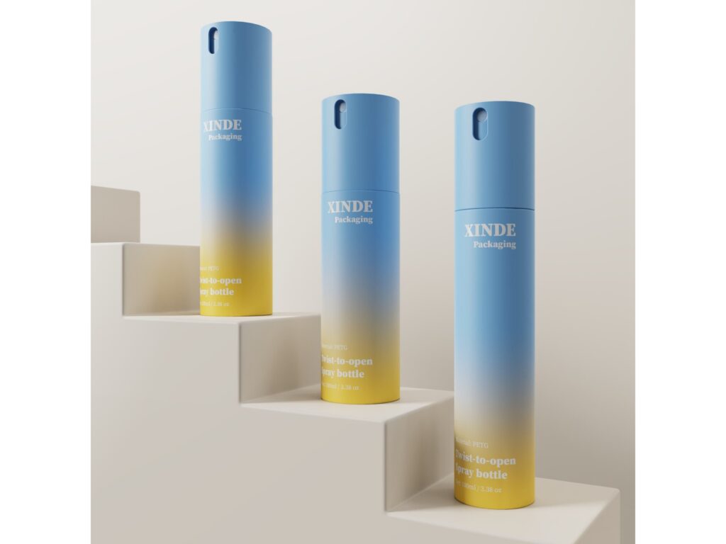Three blue-to-yellow gradient twist-to-open spray bottles made of PETG, 100ml, placed on white stepped display platform